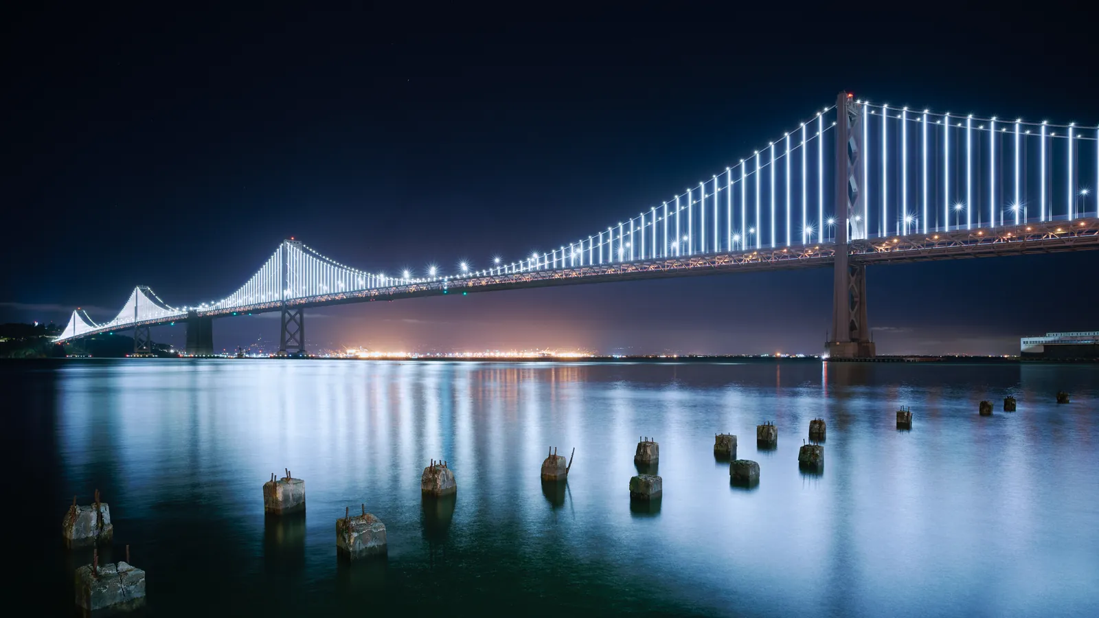The San Francisco Bay Bridge and downtown skyline at night